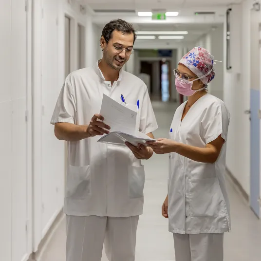 Deux praticiens dans le couloir étudiant un dossier patient de la Polyclinique Lyon Nord