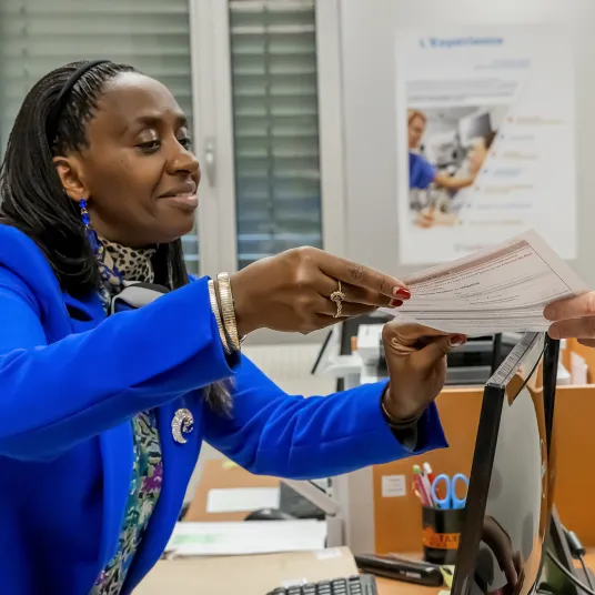 la secrétaire remet des documents à une patiente