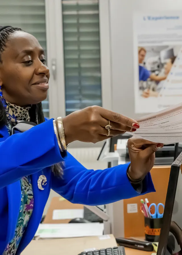 la secrétaire remet des documents à une patiente