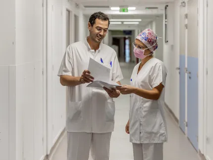Deux praticiens dans le couloir étudiant un dossier patient de la Polyclinique Lyon Nord