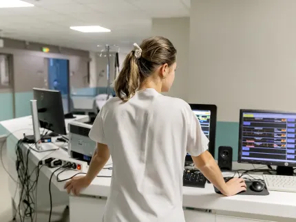 Infirmière de dos travaillant sur l'ordinateur à la Polyclinique Lyon Nord