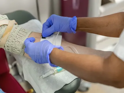 Un médecin réalise une prise de sang sur une patiente