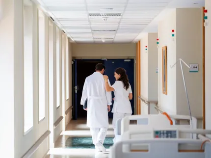 Un médecin et une infirmière marchant dans un couloir. Groupe Vivalto Santé