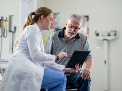 Une femme médecin expliquant au patient sa pathologie en lui montrant une radiologie, Groupe Vivalto Santé.