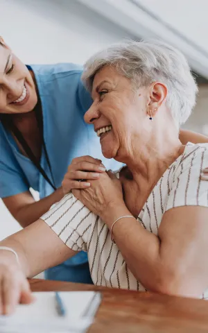 Infirmière à domicile avec une patiente âgée. 