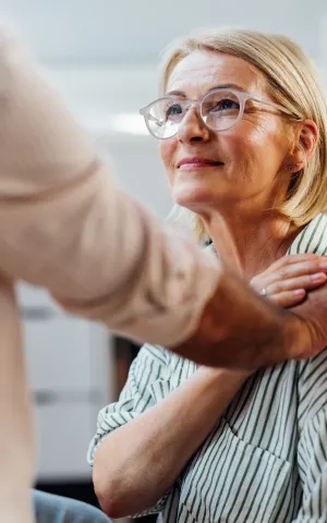 Patiente âgée avec la main de son docteur sur l'épaule.