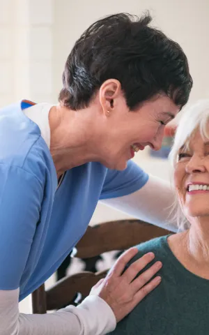 Une infirmière et sa patiente en train d'échanger des sourires.