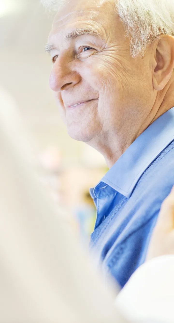 Patient agé souriant au médecin qui lui touche l'épaule en signe d'empathie, Groupe Vivalto Santé