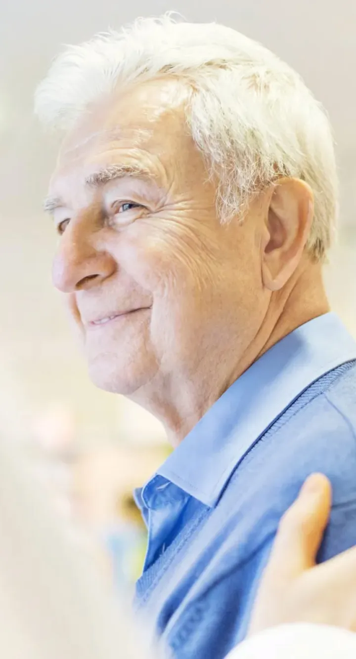 Patient agé souriant au médecin qui lui touche l'épaule en signe d'empathie, Groupe Vivalto Santé